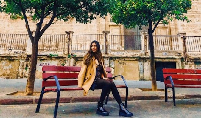 Natasha, a solo female traveler and English teacher in Spain sitting on a bench