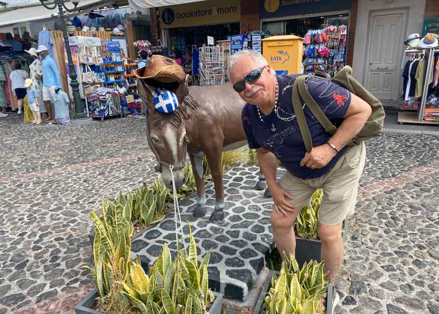  image depicting a man next to the shops in Santorini