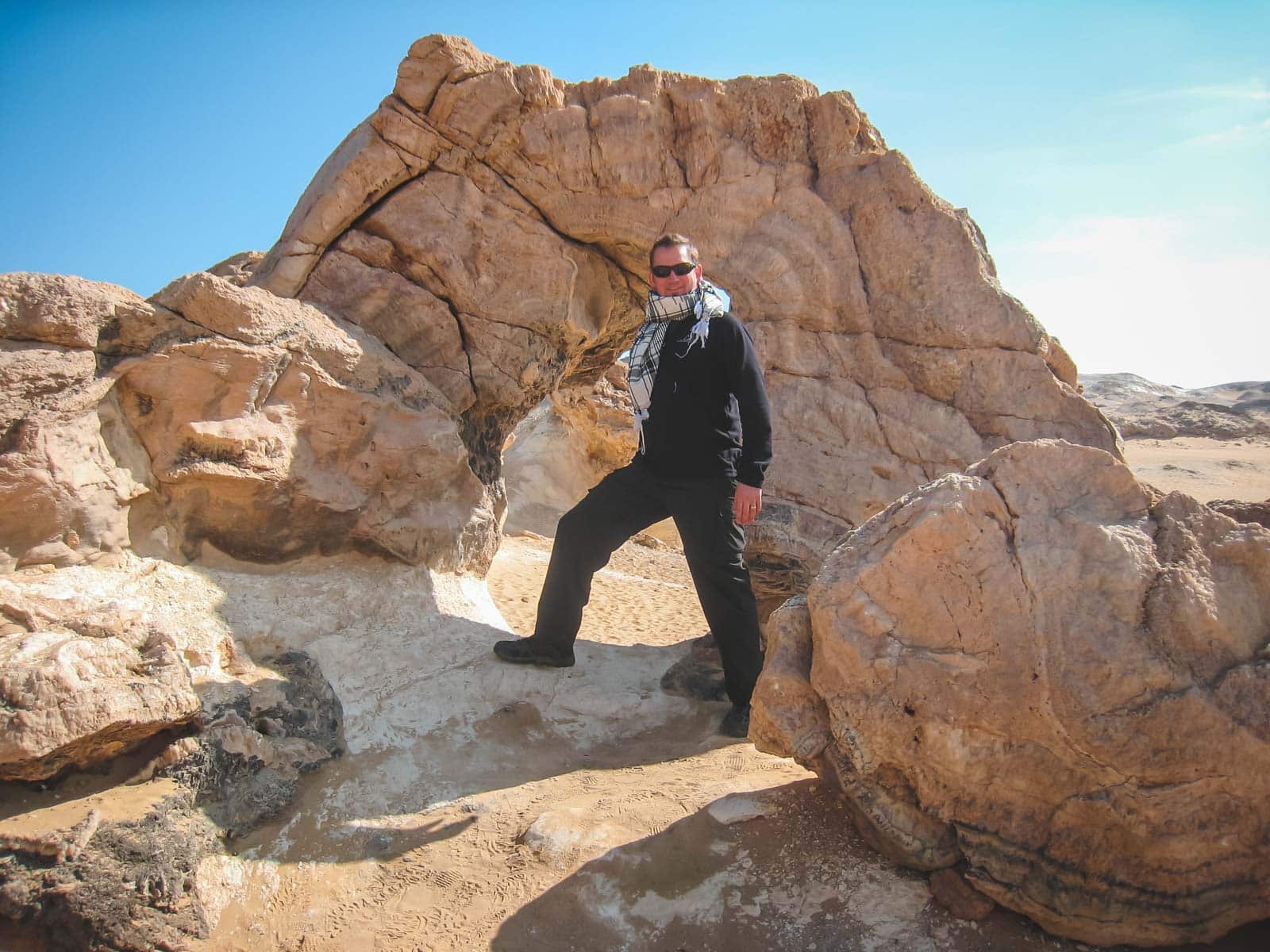 Dave from The Planet D in lightweight, loose-fitting clothing and hats exploring the White desert in Egypt, showing appropriate and respectful attire for Egypt's climate.